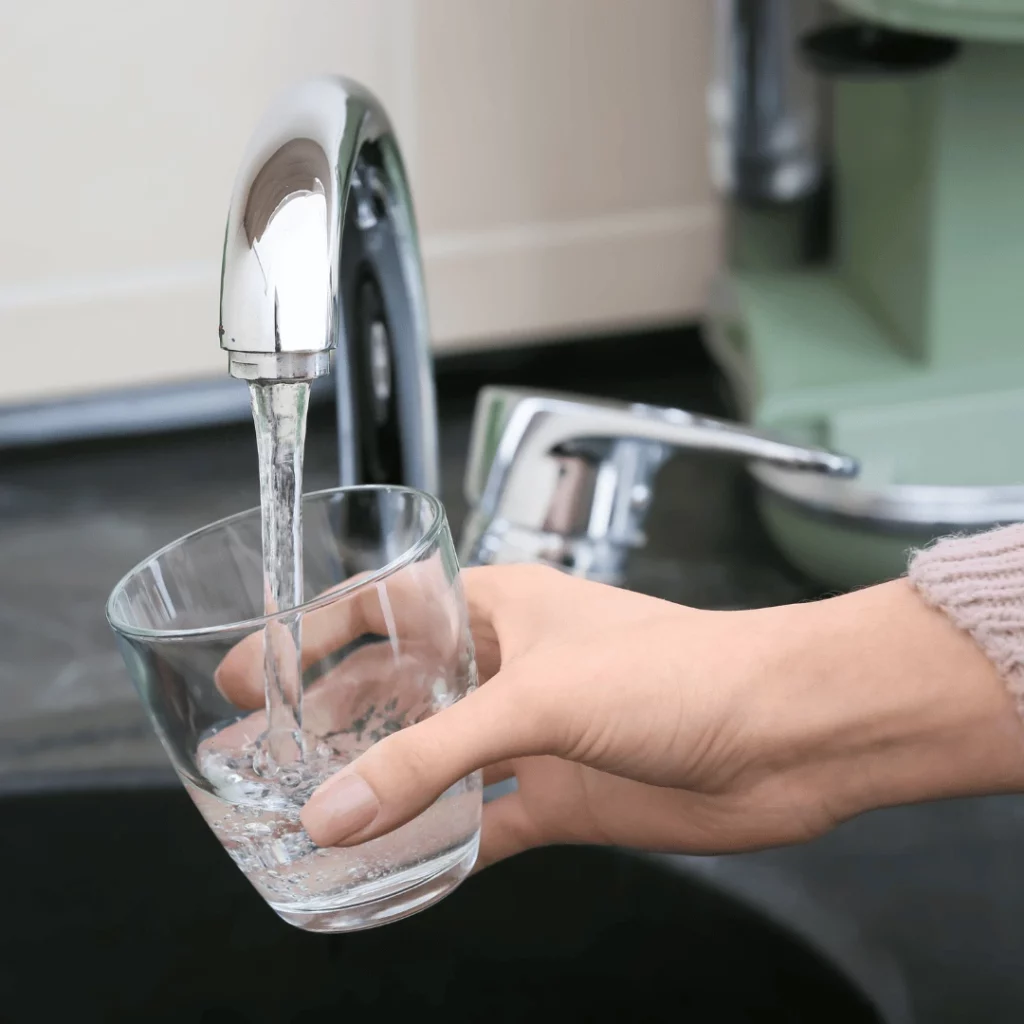 het (11) Une personne qui se sert un verre d'eau au robinet