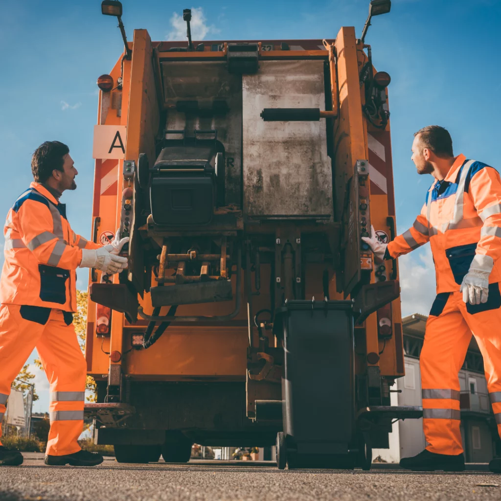 Deux éboueurs en train de vider les poubelles d'ordures ménagères dans le camion